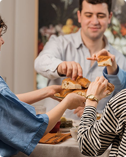 People sharing sandwiches at a table in a casual indoor setting