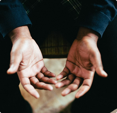 Two outstretched hands reaching toward each other over a blurred background