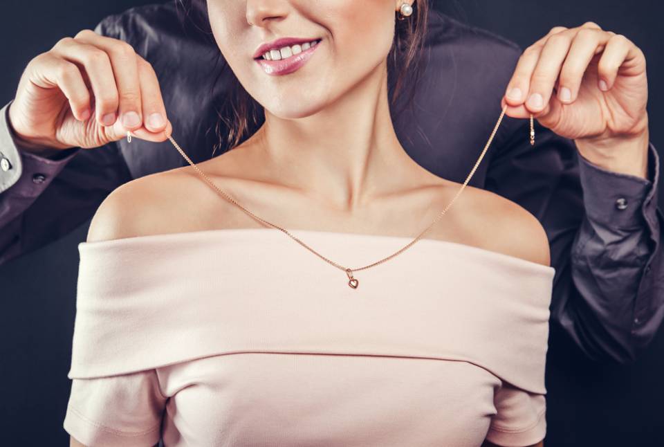 persona che mette la collana al collo di una donna
