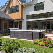 Modern home backyard with a large covered hot tub or spa and landscaped garden beds