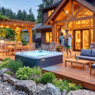 Backyard deck with fire pit, lounge chairs, and an above-ground pool beside a white house at dusk