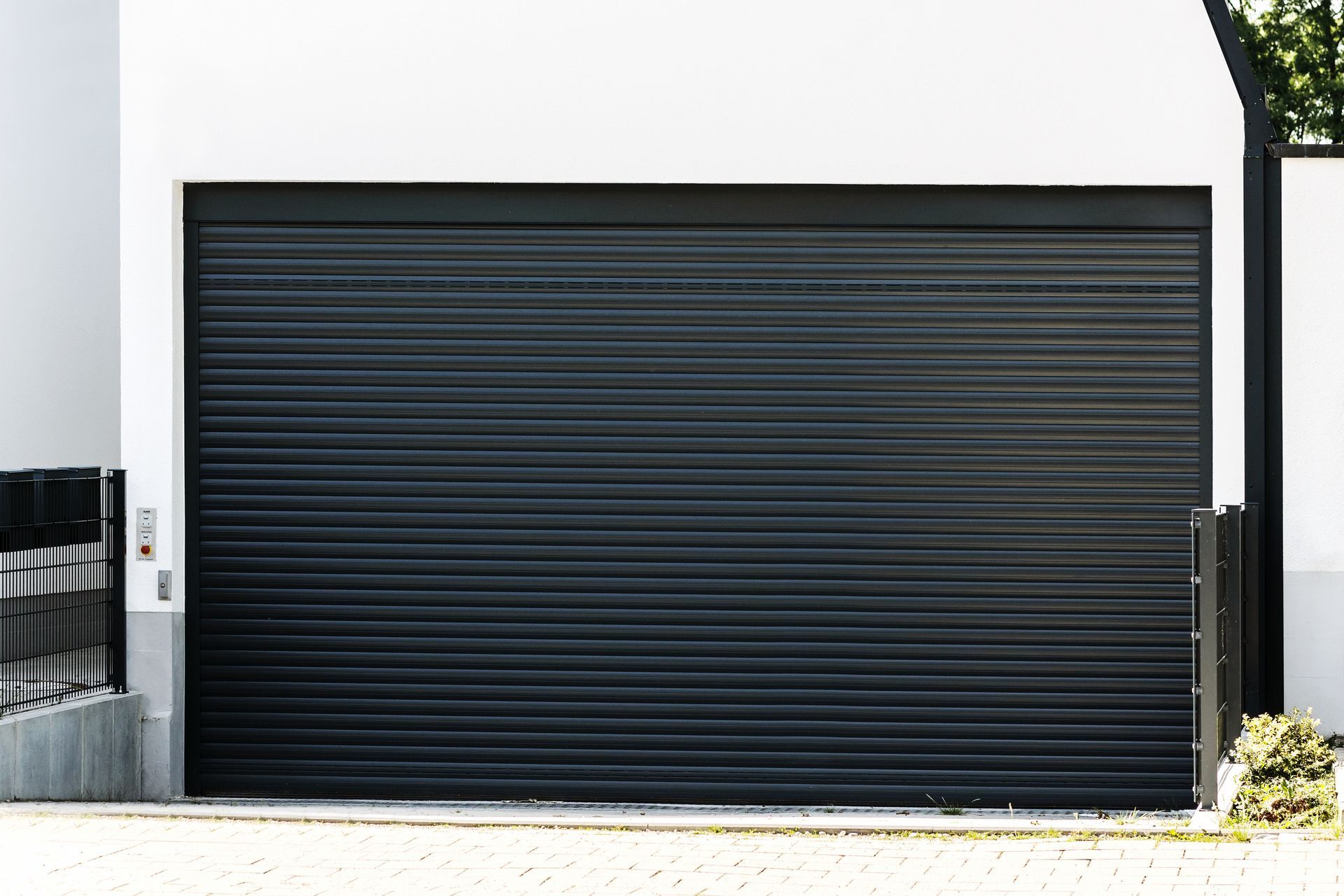 Black roll-up garage door on a white building exterior