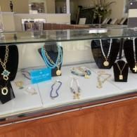Jewelry display case with necklaces and bracelets on black and white stands