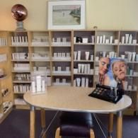 Small office with bookshelves, round table, and a display stand showing two faces.