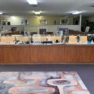 Empty jewelry store counter with glass display cases and patterned floor rug