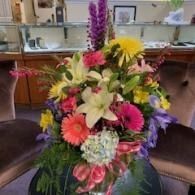Colorful mixed-flower bouquet with lilies and daisies on a table in a home kitchen