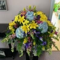 Colorful bouquet of yellow, blue, and purple flowers in a black vase on a table