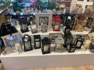 Display of assorted decorative lanterns in black, white, gold, and red on white shelves