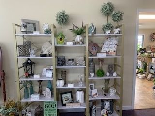 Decorative wooden shelves with plants, framed art, candles, and home decor in a bright room