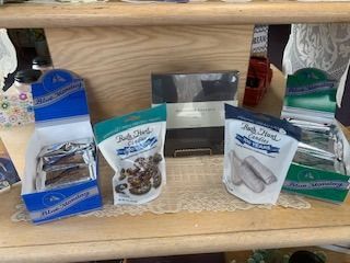 Assorted packaged snack and pet treats displayed on a wooden shelf