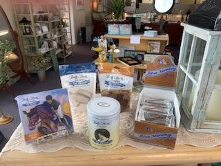 Assorted packaged goods displayed on a table in a cozy shop or market interior.