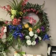 Floral wreath with pink, white, blue, and yellow flowers on a wall