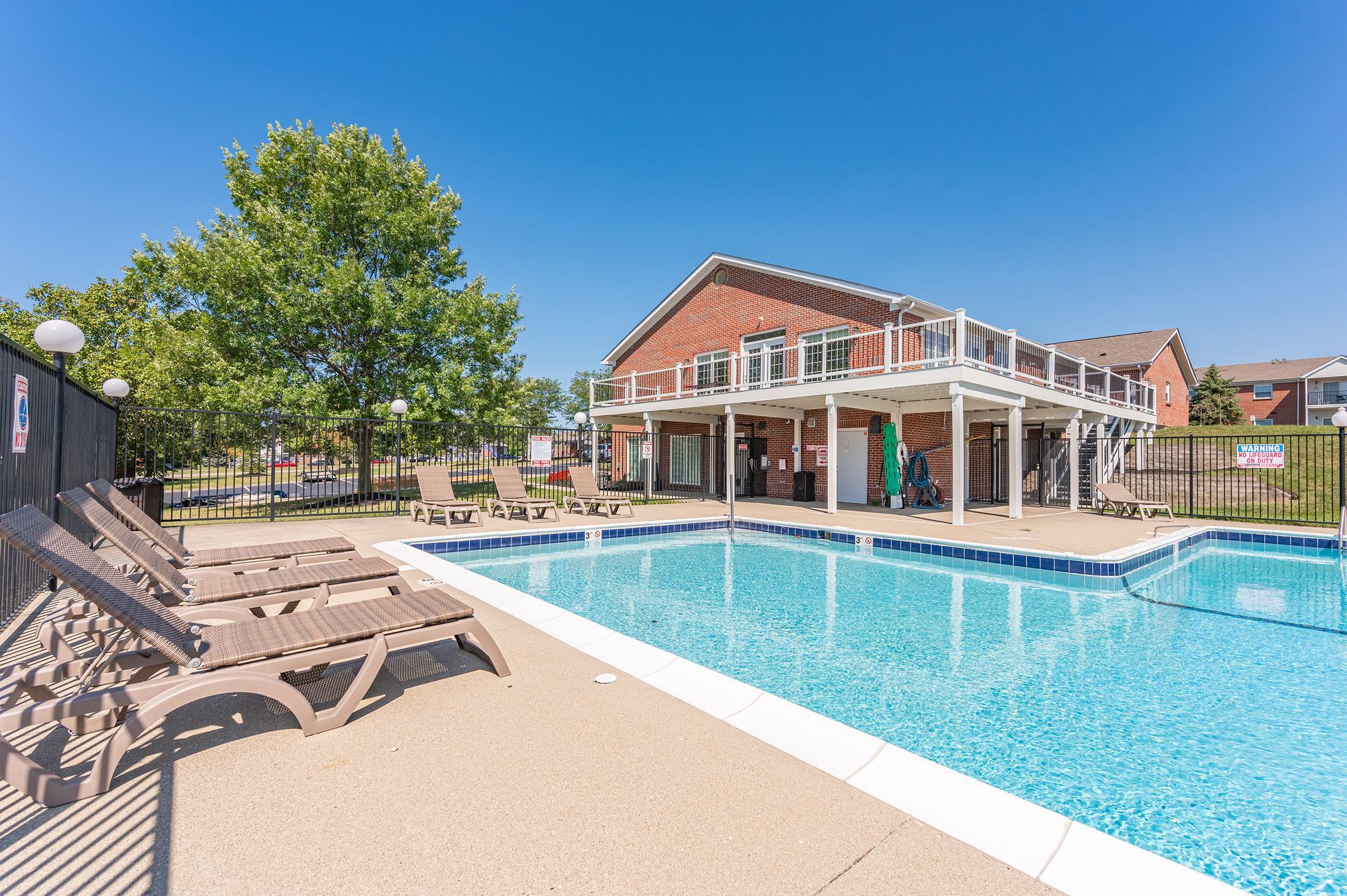 Bridgewater Crossing community swimming pool with lounge chairs, umbrellas, and clubhouse view.