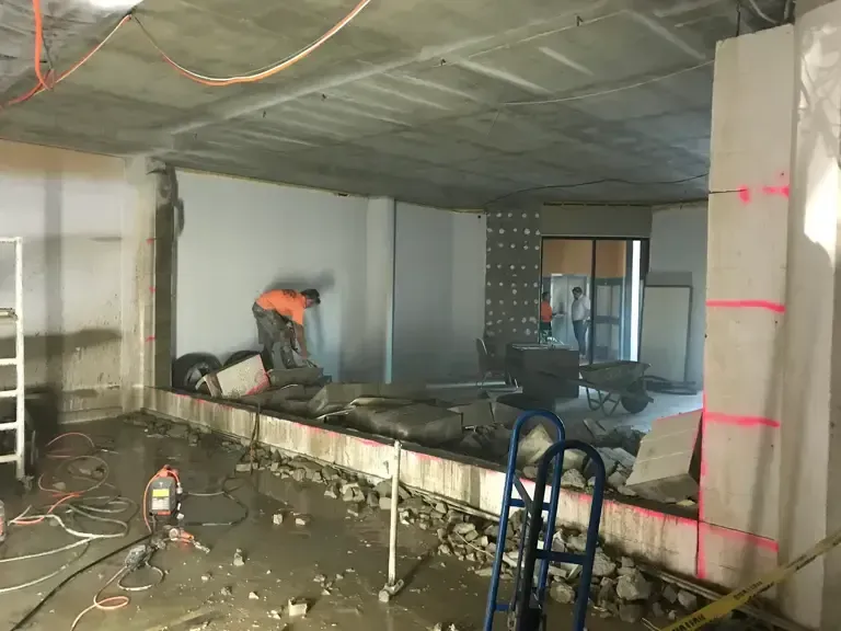 Worker Cutting Concrete In A Building Under Construction — Concrete Cutting in Bundaberg, QLD