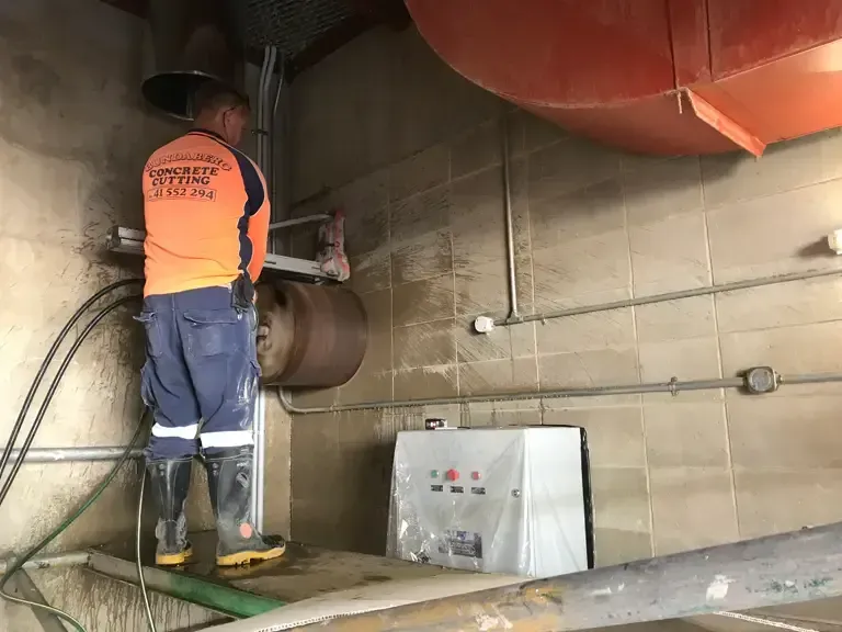 Man Core Drilling The Wall — Concrete Cutting Services in Bundaberg, QLD
