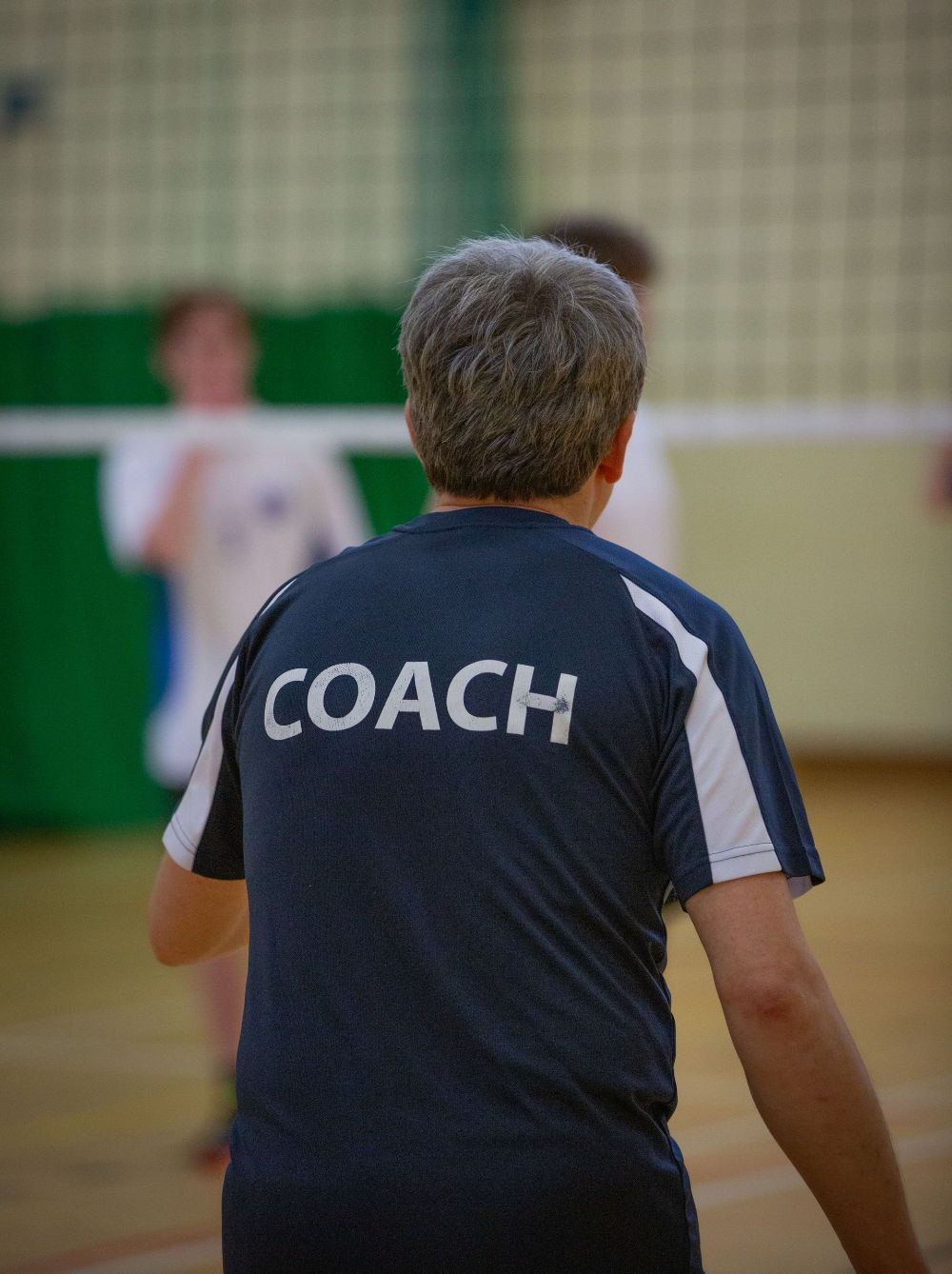 A man wearing a shirt that says coach on the back