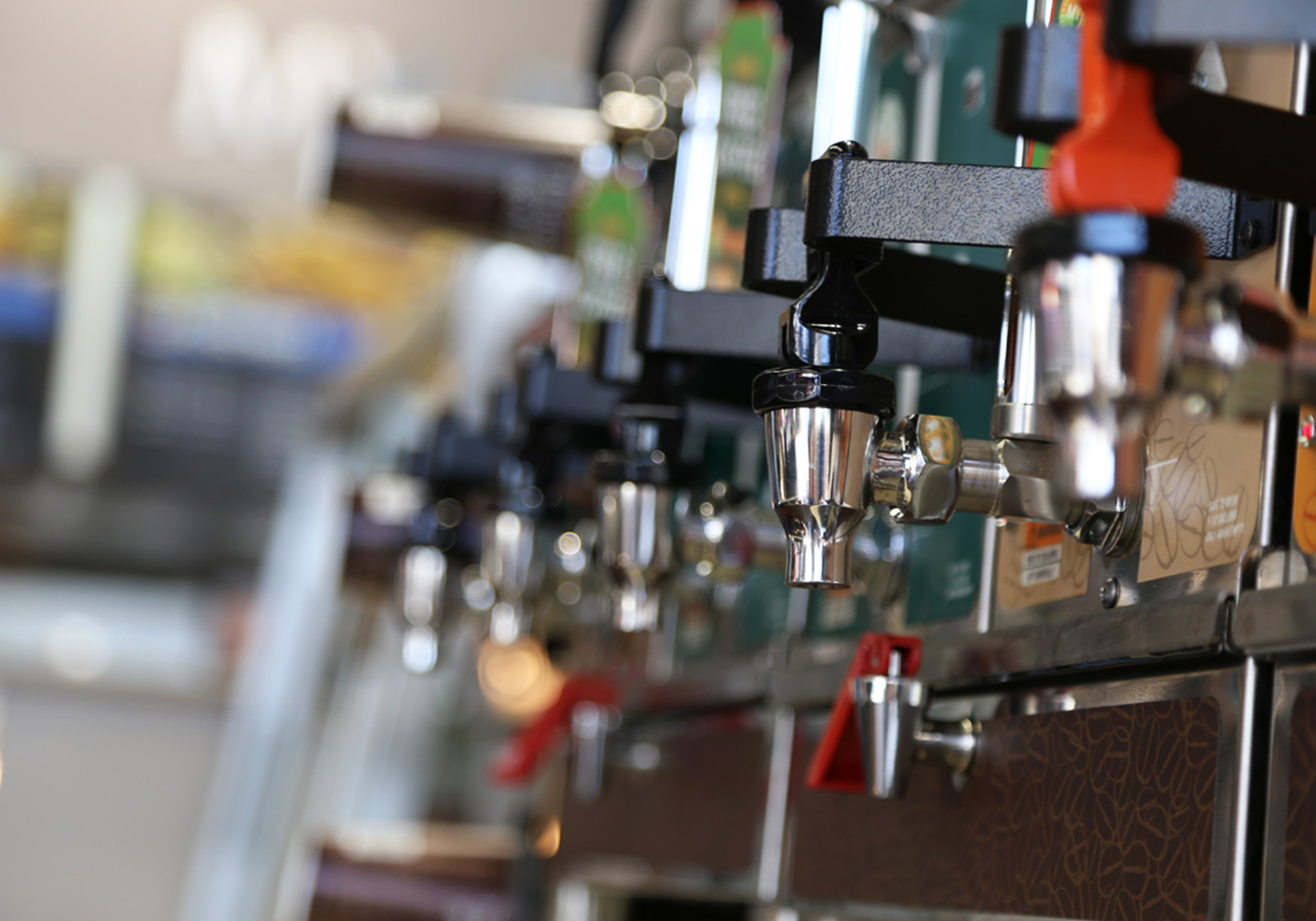 Coffee and beverage dispensers with silver spouts and black handles.