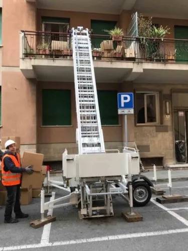 Un uomo è in piedi accanto a una scala in un parcheggio.