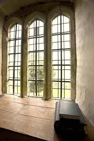 a book is sitting on a wooden table in front of a window .
