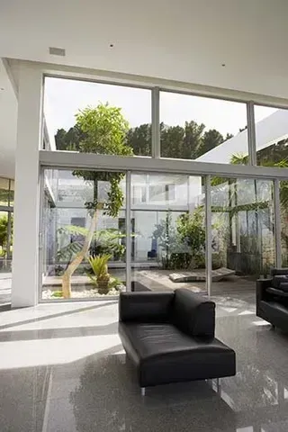 a living room with a couch and chairs and a large window