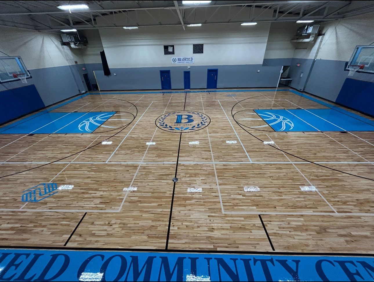 Basketball court with blue and wooden tones; the 