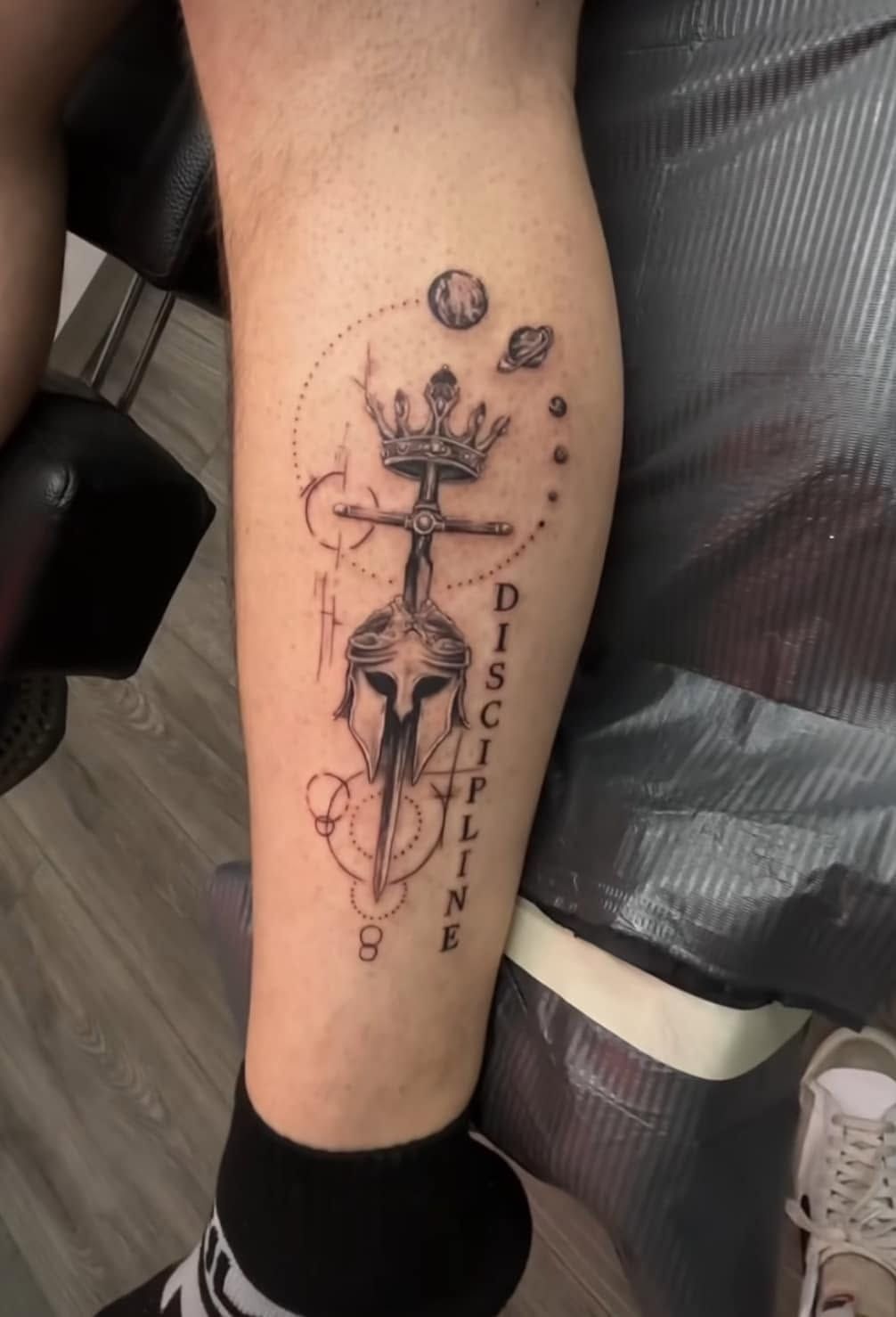 Purple flower and hummingbird tattoo on a person’s shoulder blade.