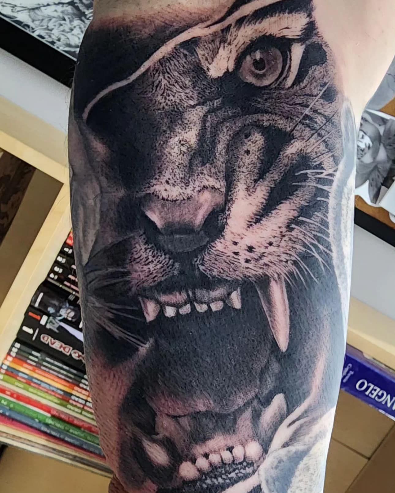 Black-and-white roaring tiger tattoo on a person’s upper arm