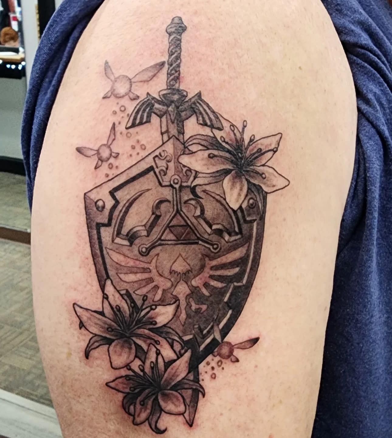 Close-up of a skull tattoo on a forearm, with dark shading and orange accents on the side