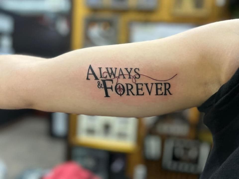Arm with “Always & Forever” tattoo in black script