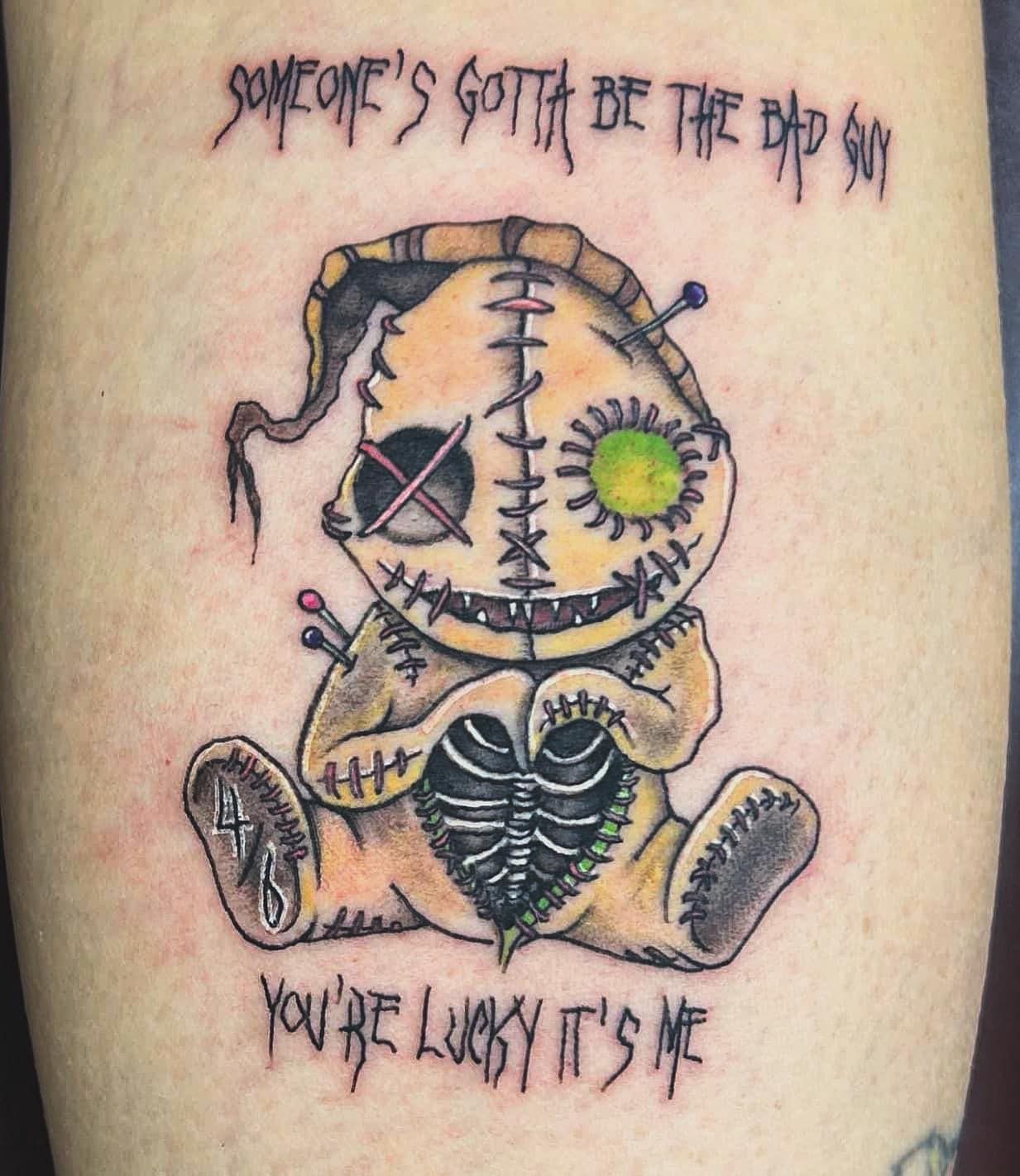 Stitched doll tattoo with “Someone’s gotta be the top dog” and “You’re lucky it’s me” text