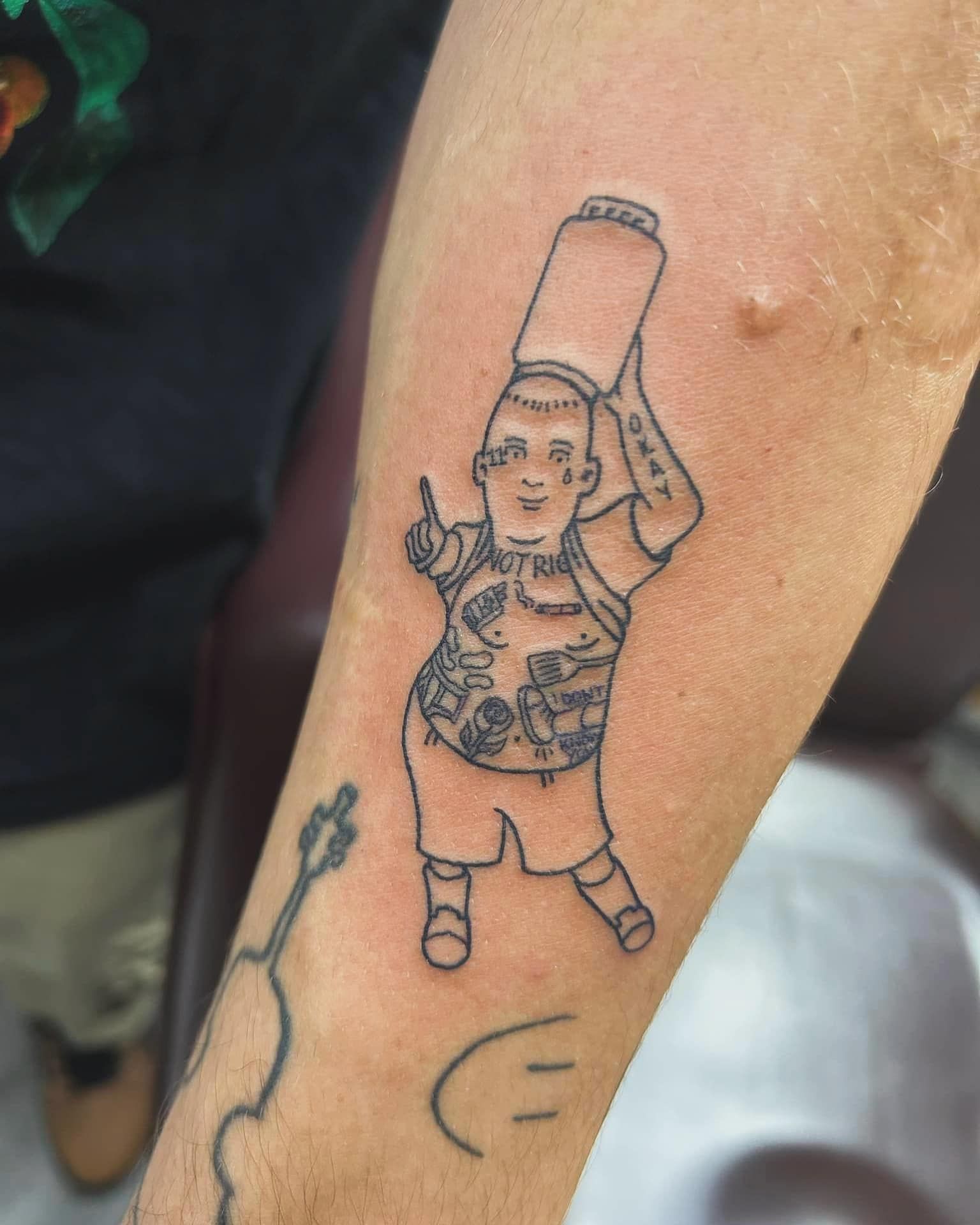 Line tattoo of a cartoon child holding a cup on a forearm