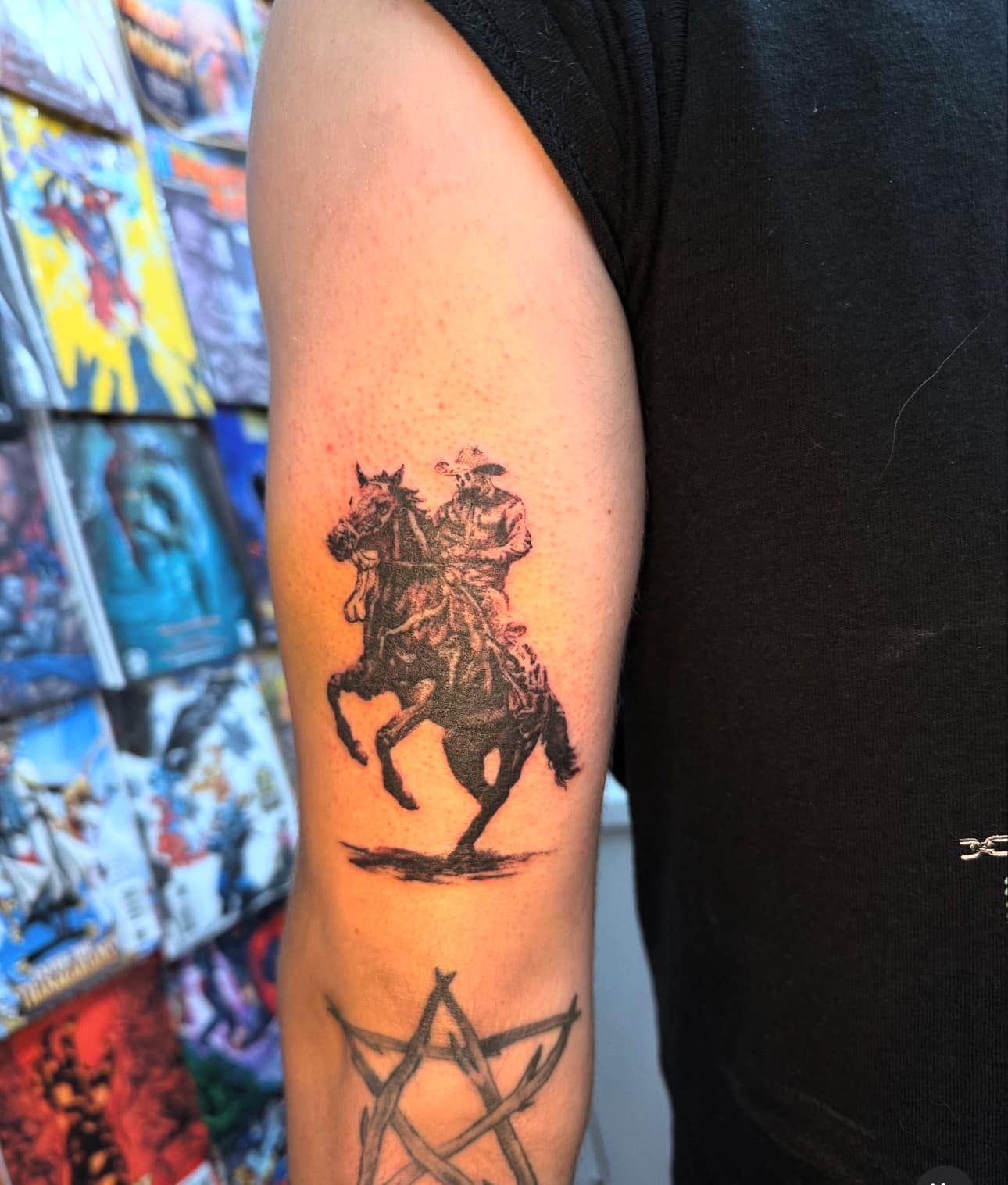 Arm tattoo of a rearing horse on a person’s upper arm, with another geometric tattoo below.
