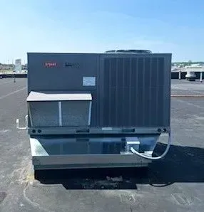 Large rooftop HVAC unit on a flat roof under a blue sky