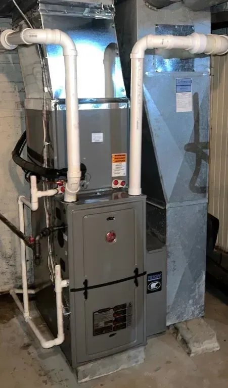 Basement HVAC furnace and ductwork with white insulated pipes and blue insulation wrap