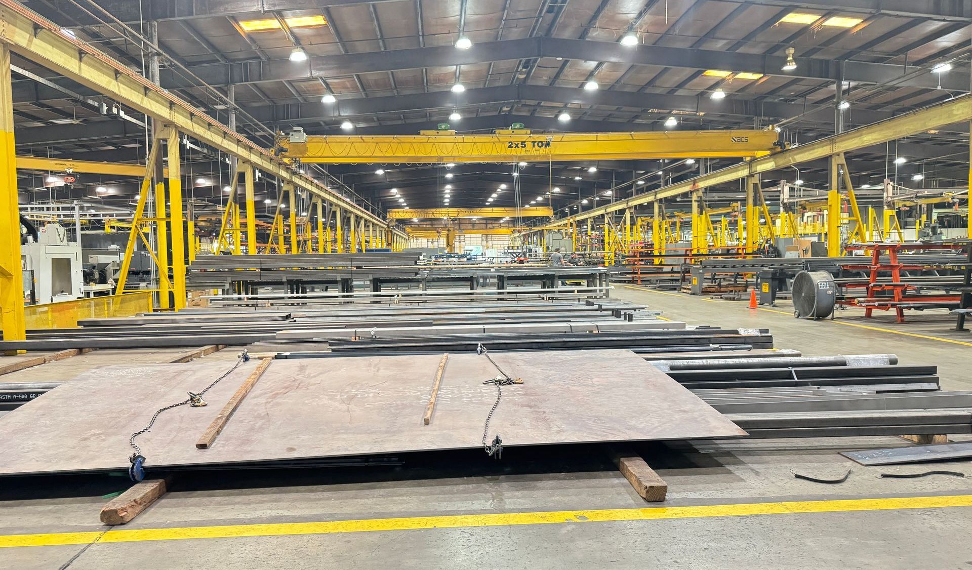 AutoQuip's warehouse filled with lots of metal pieces and a crane.