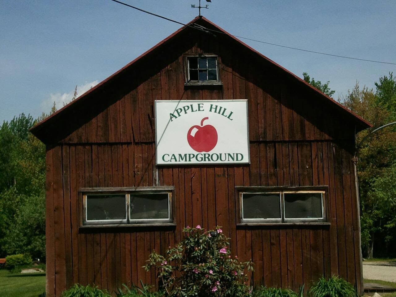 Wooden Apple Hill Campground cabin with a red apple sign on the front.