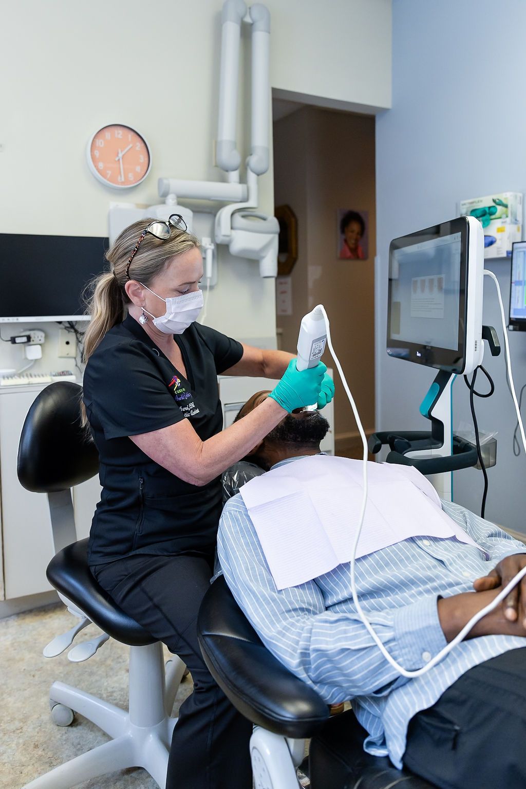 Dental hygienist cleaning a patient’s teeth in a clinic