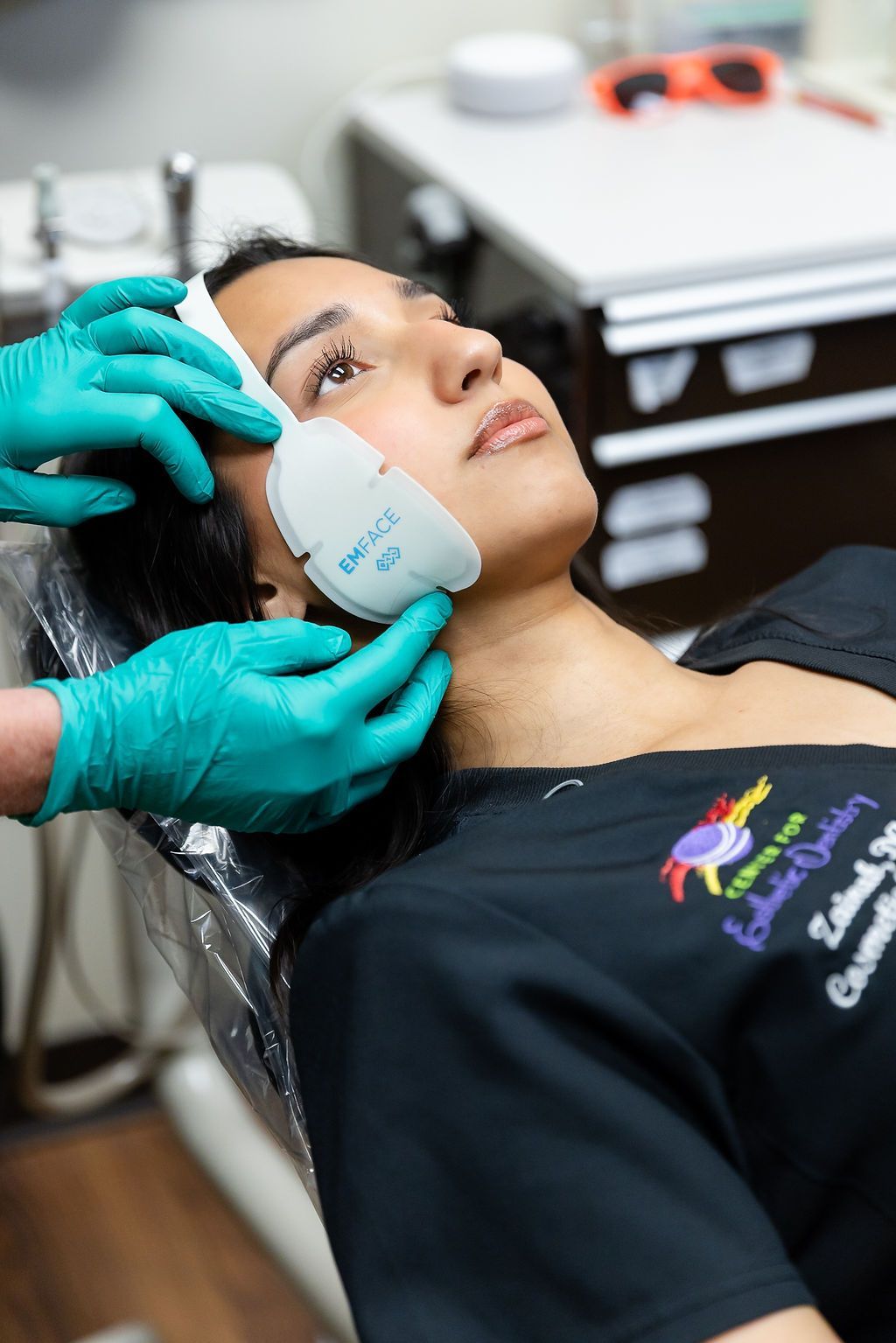 A person receiving a facial treatment with a handheld device