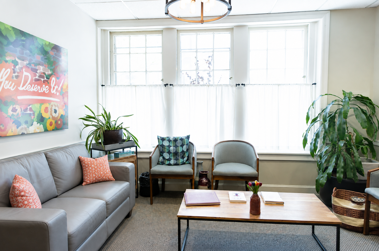 Bright living room with gray sofa, two armchairs and coffee table