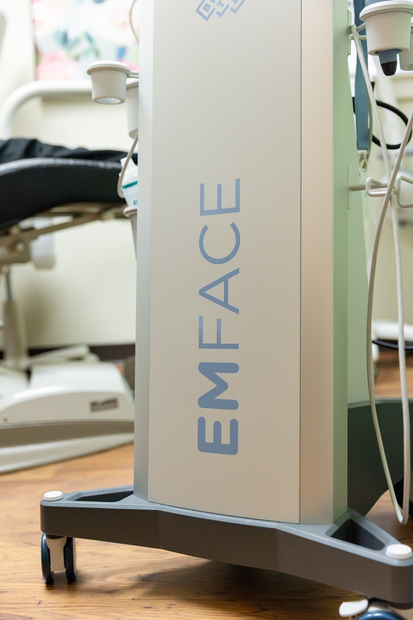 EMFACE device in a clinic, with a beige tower on a wheeled base and cables attached