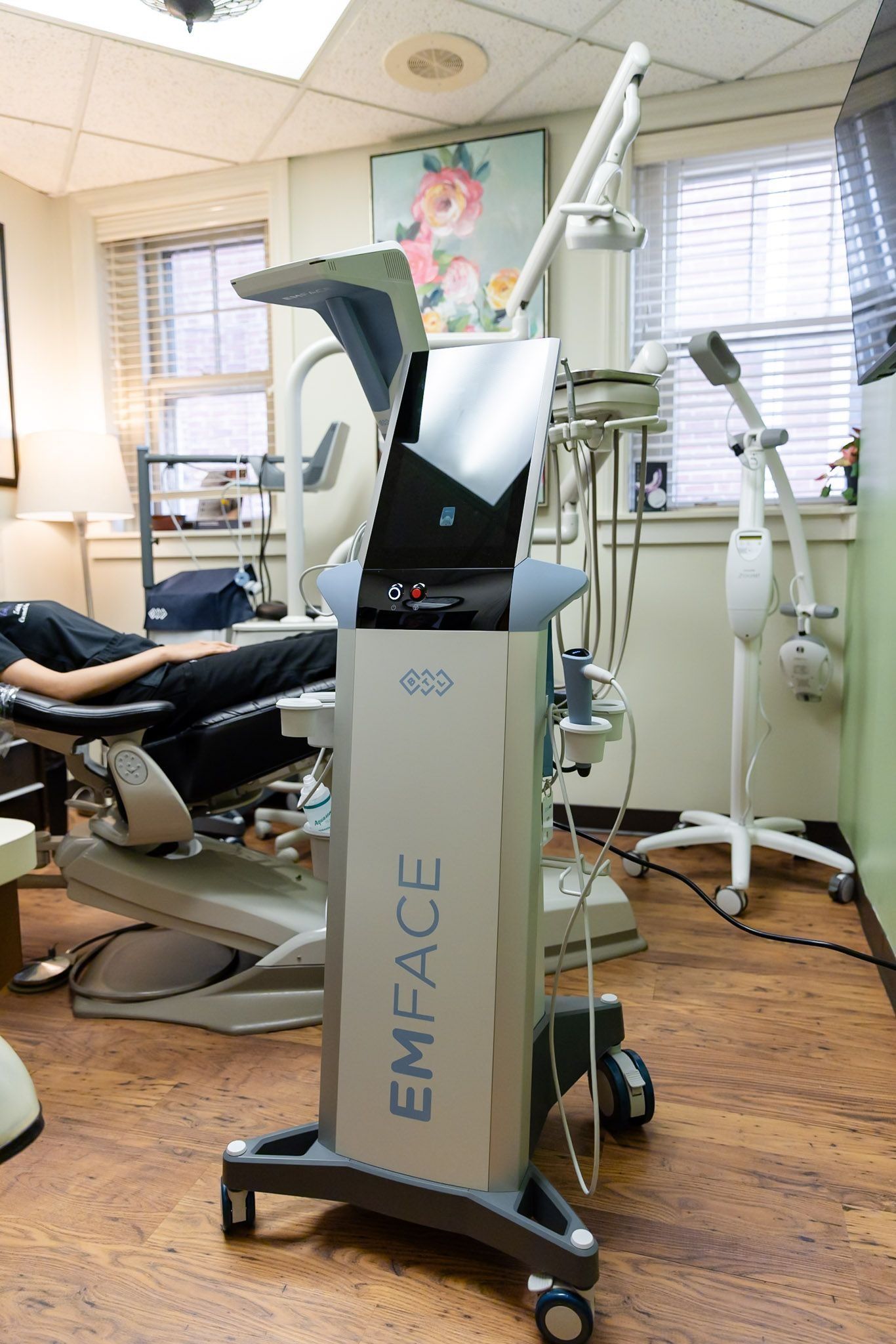 EMFACE treatment machine in a clinic room beside a reclining chair