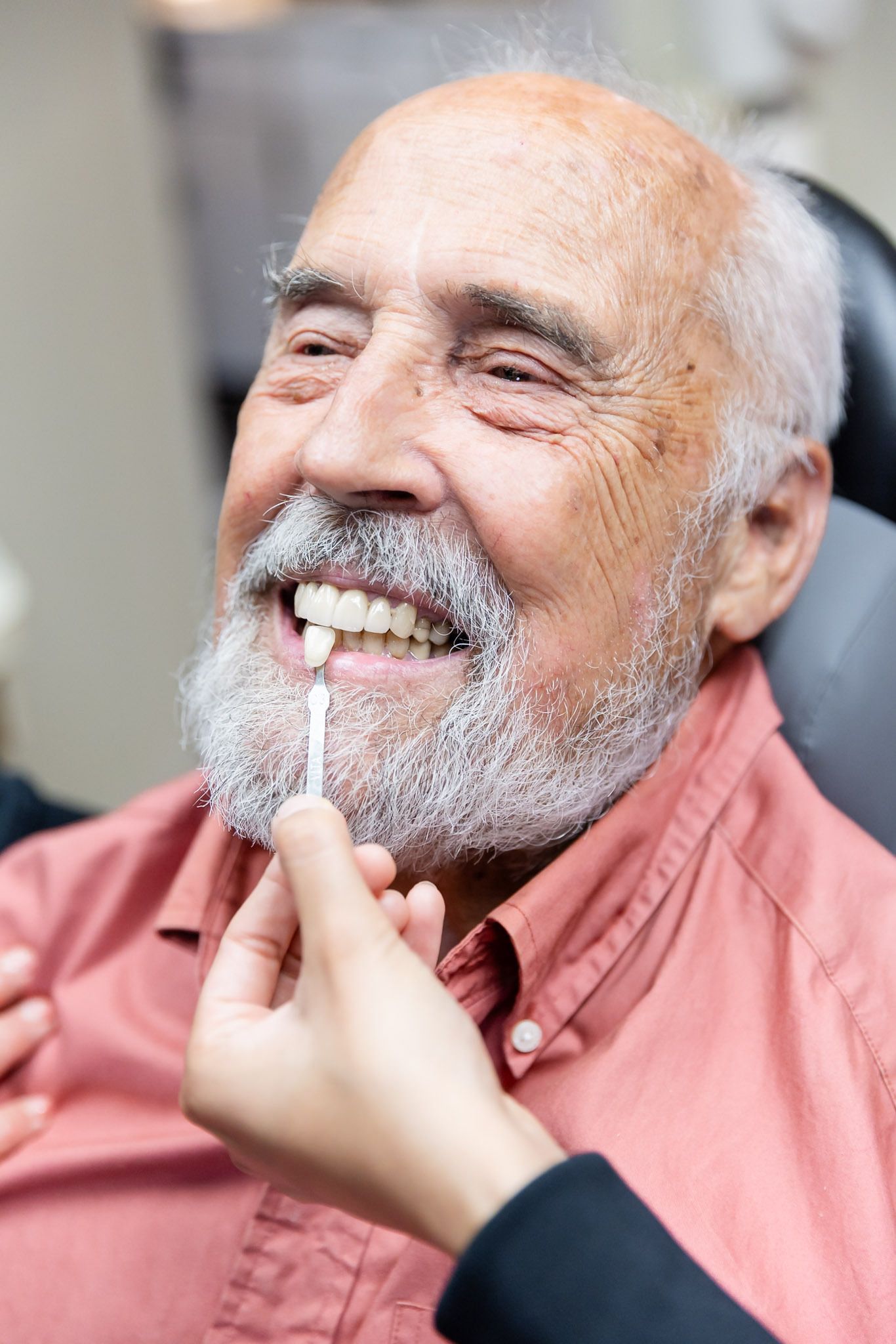 Smiling man having teeth cleaned with a dental tool