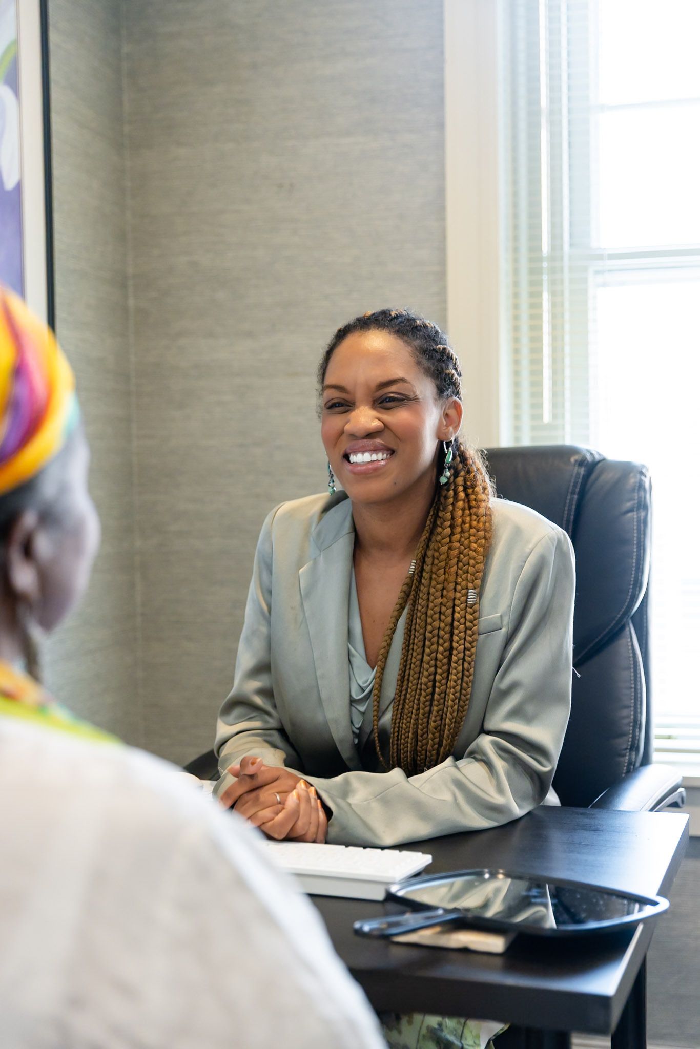 Smiling person seated at a desk in a bright office