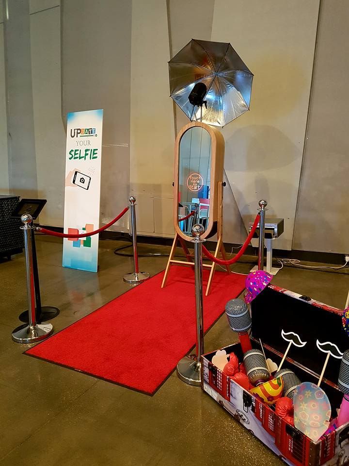 Red carpet display with velvet ropes, a mirror, and a decorated cart of toys or candy indoors.