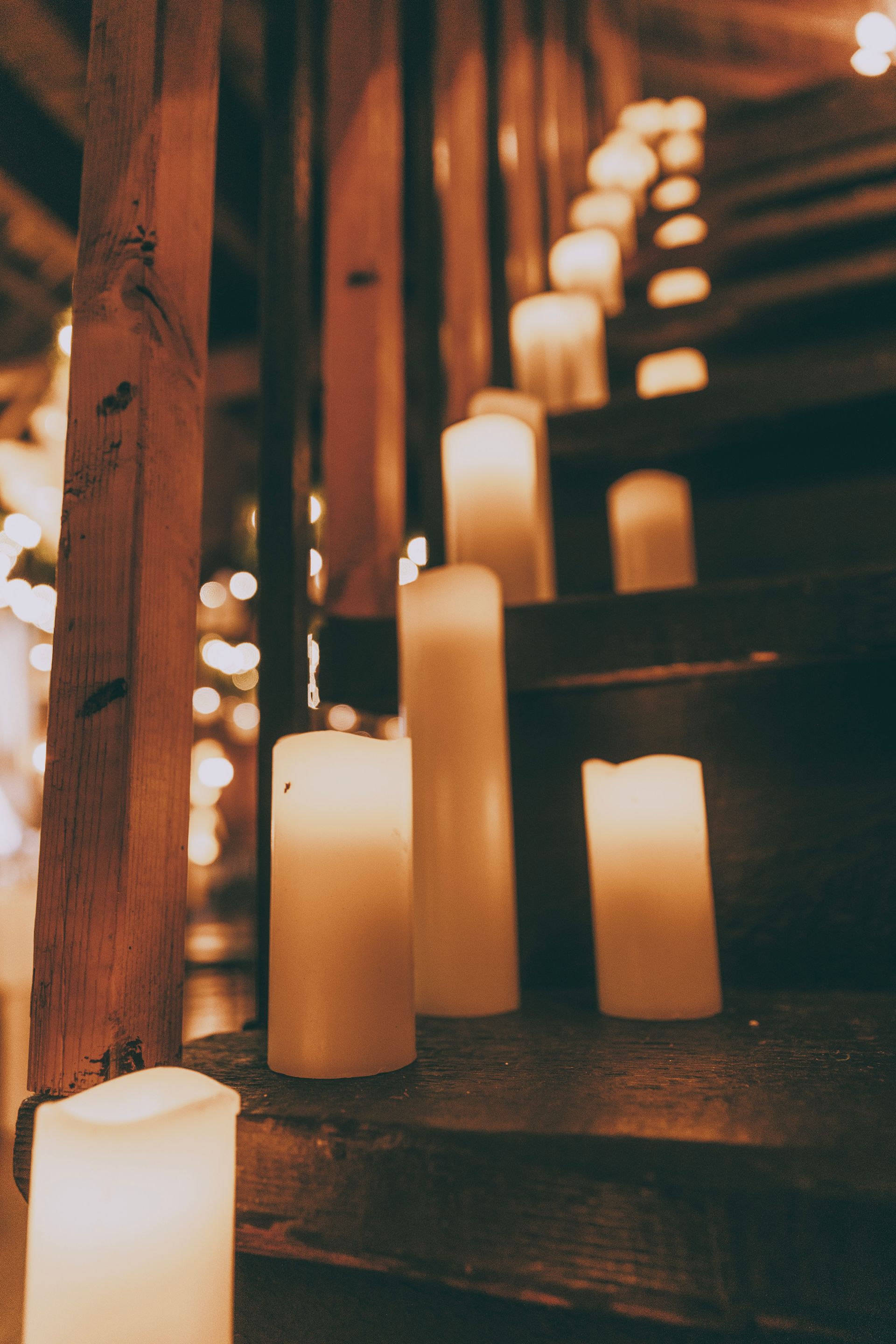 Lit candles glowing on wooden steps in a dim staircase