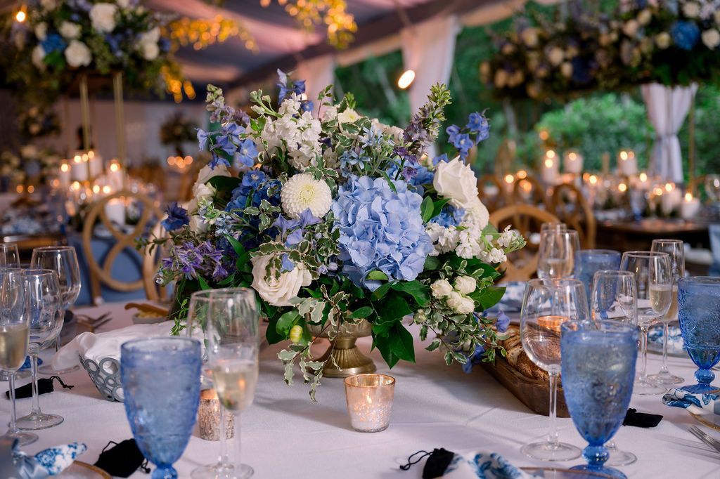 Elegant banquet table with blue glassware and a white-and-blue floral centerpiece at a formal event