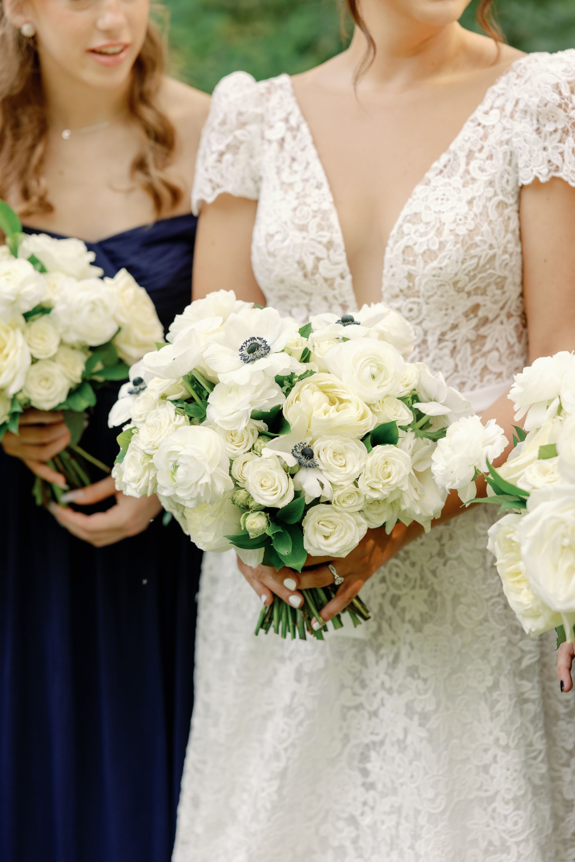 Bridal bouquet of white roses held by a bride in a lace wedding dress