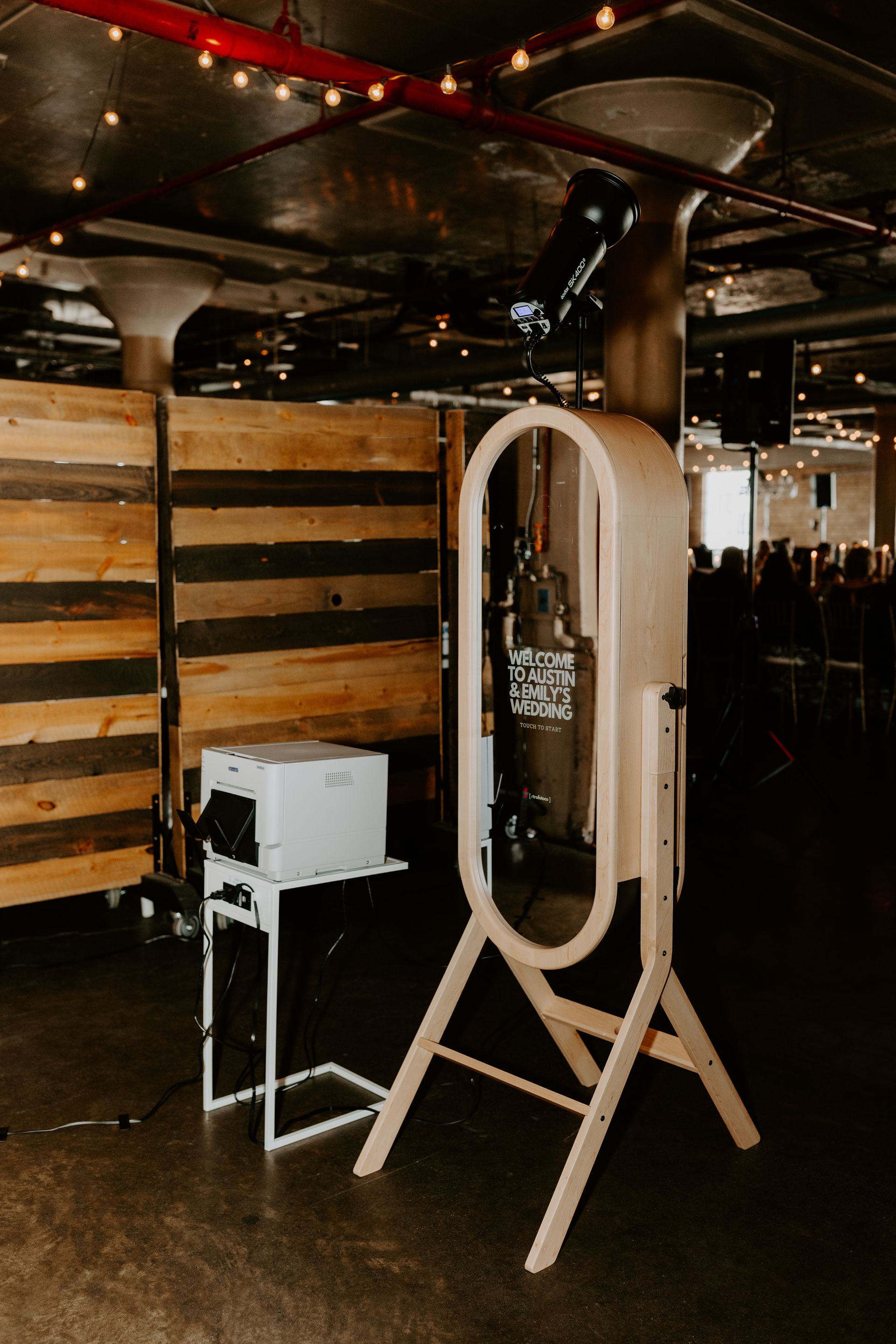 White standing mirror next to a small white cabinet in a dimly lit restaurant or bar interior