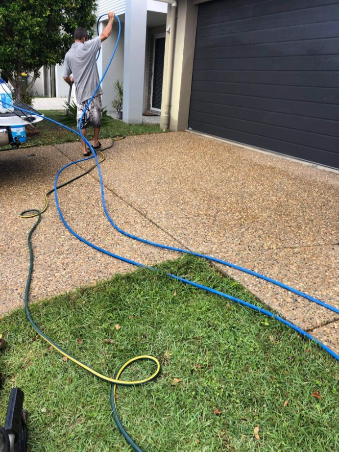 Man Fixing The Hose While Cleaning The Floor — Cleaners in Sunshine Coast, QLD
