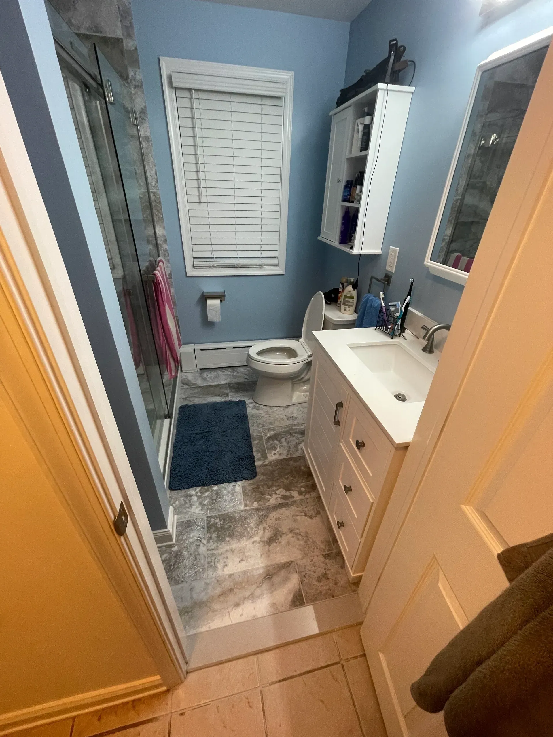 Bathroom with white vanity, toilet, and shower. 